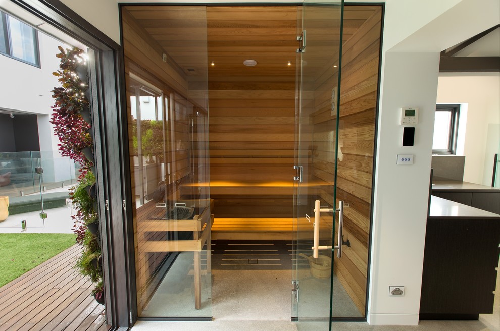 Diseño de sauna contemporánea de tamaño medio con armarios tipo vitrina, puertas de armario de madera clara, paredes marrones, suelo de madera oscura, encimera de madera y suelo gris