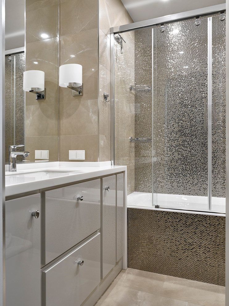 Exemple d'une salle de bain principale tendance avec un placard à porte plane, des portes de placard grises, une baignoire en alcôve, un mur beige et un lavabo encastré.
