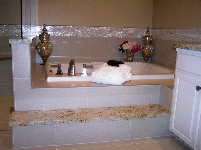 Foto di una stanza da bagno chic con lavabo sottopiano, ante con bugna sagomata, ante bianche, top in granito, vasca da incasso, doccia a filo pavimento, piastrelle bianche e piastrelle in gres porcellanato