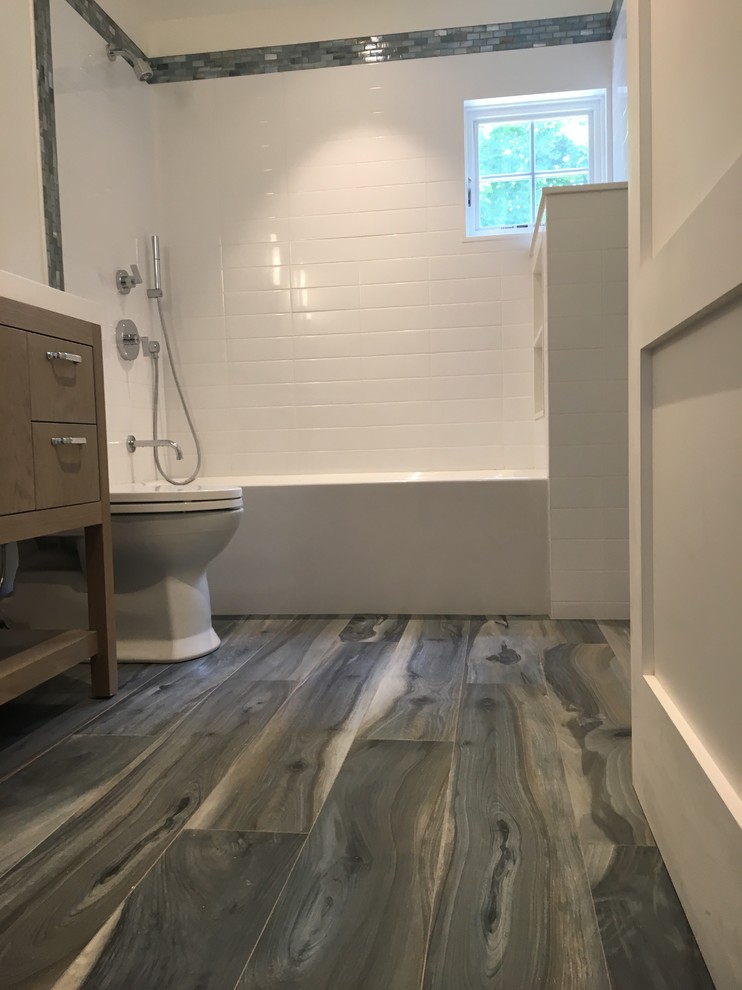 Inspiration for a mid-sized transitional 3/4 white tile and subway tile dark wood floor and black floor bathroom remodel in New York with flat-panel cabinets, light wood cabinets, a one-piece toilet, white walls, an integrated sink and solid surface countertops