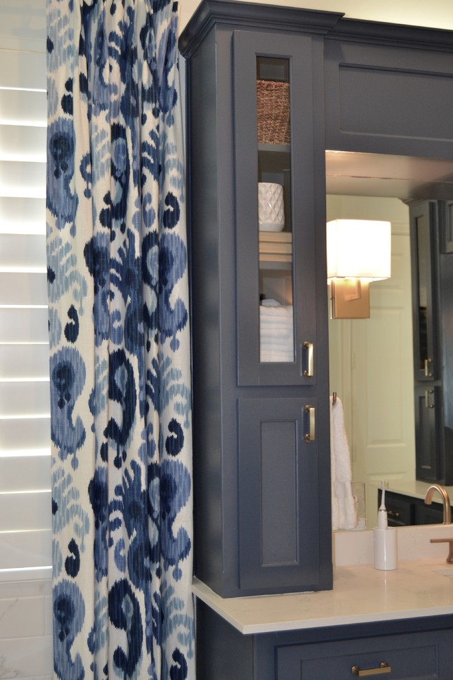 На фото: большая главная ванная комната в стиле неоклассика (современная классика) с фасадами в стиле шейкер, синими фасадами, отдельно стоящей ванной, угловым душем, раздельным унитазом, белой плиткой, керамогранитной плиткой, белыми стенами, полом из керамогранита, врезной раковиной, столешницей из искусственного кварца, белым полом и душем с распашными дверями с