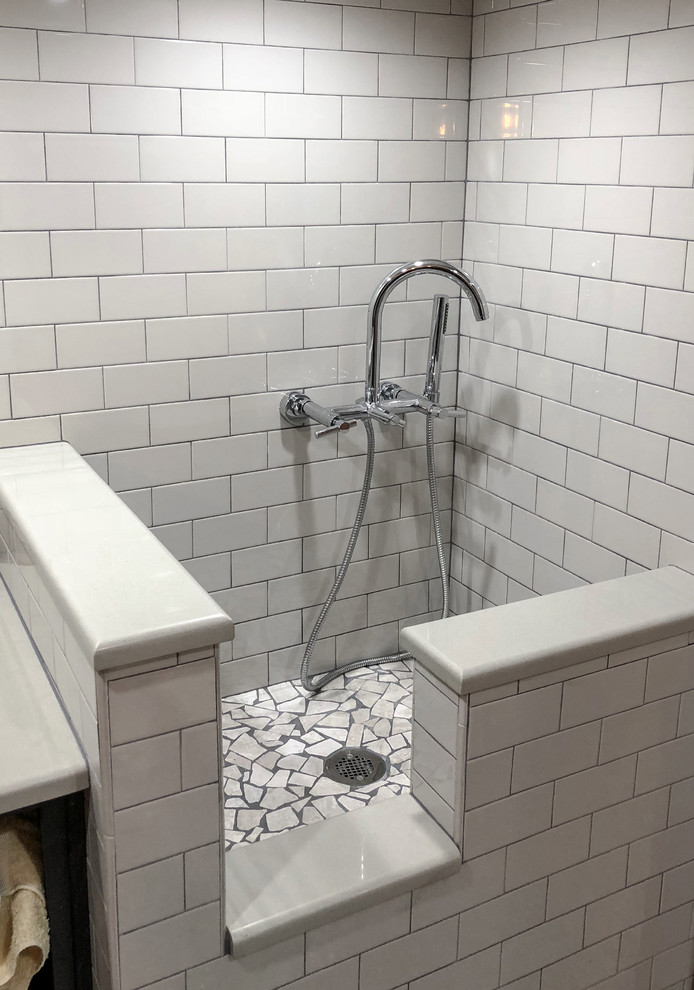 Inredning av ett industriellt mellanstort beige beige badrum med dusch, med släta luckor, skåp i mörkt trä, en kantlös dusch, en toalettstol med hel cisternkåpa, vit kakel, keramikplattor, gula väggar, betonggolv, ett integrerad handfat, bänkskiva i akrylsten, grått golv och med dusch som är öppen