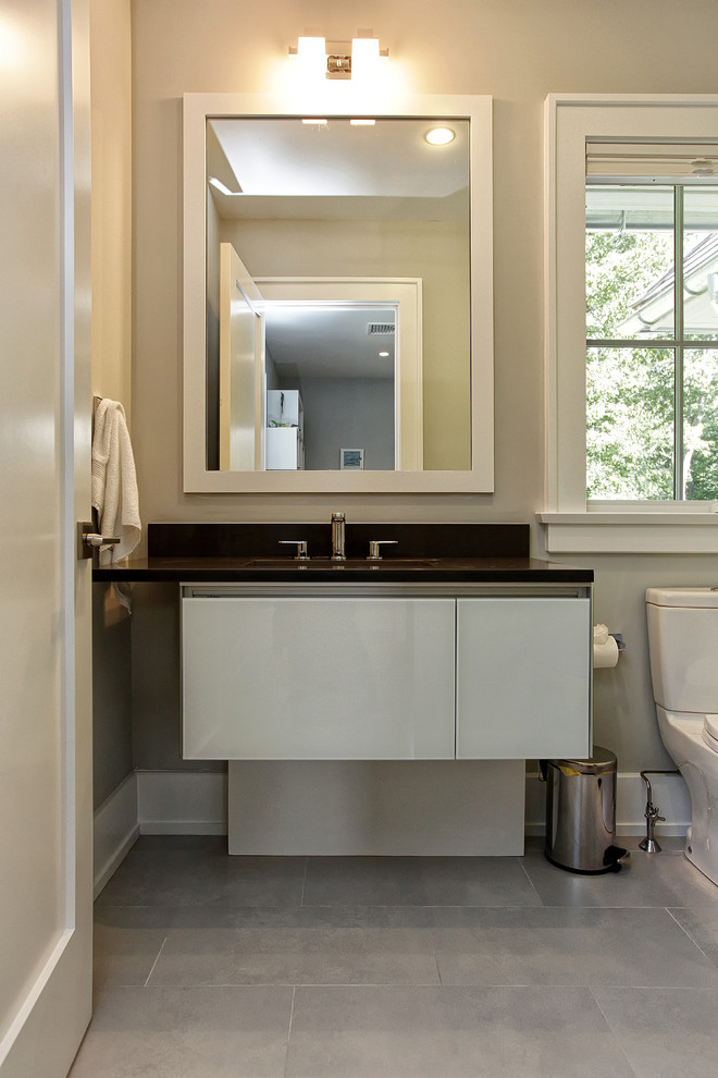 Пример оригинального дизайна: ванная комната среднего размера в стиле модернизм с душем в нише, раздельным унитазом, бежевыми стенами, полом из цементной плитки, врезной раковиной, серым полом и душем с распашными дверями