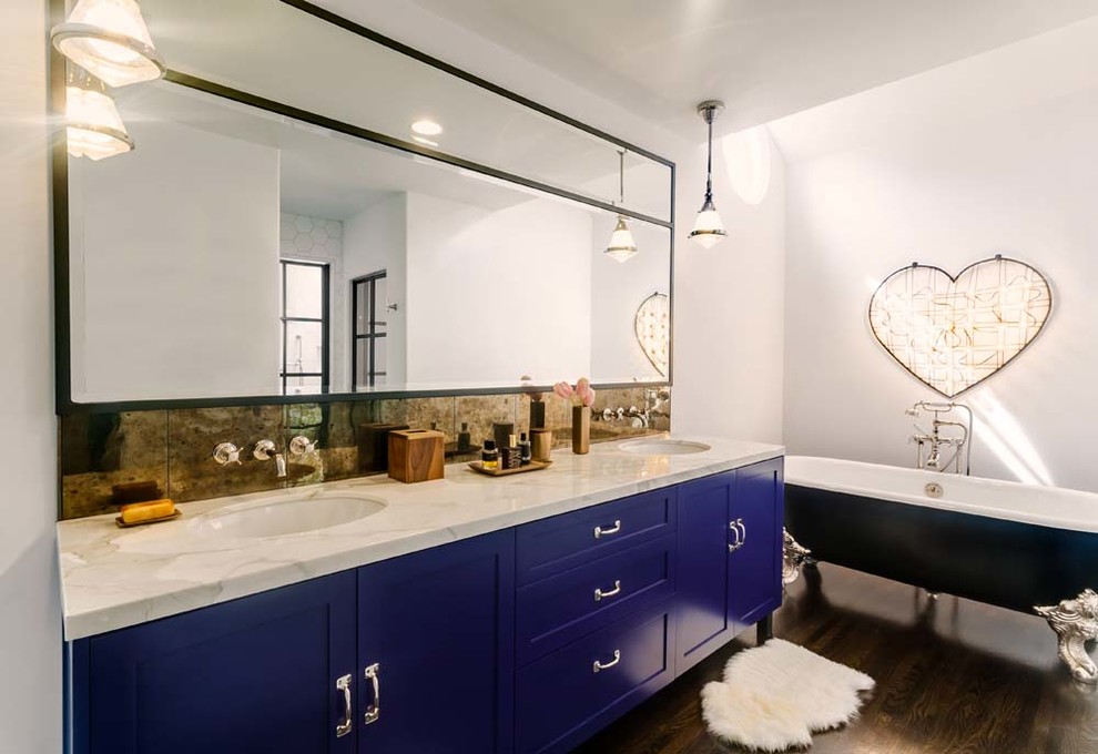 На фото: большая главная ванная комната в стиле фьюжн с накладной раковиной, фасадами в стиле шейкер, синими фасадами, мраморной столешницей, ванной на ножках, белыми стенами и темным паркетным полом