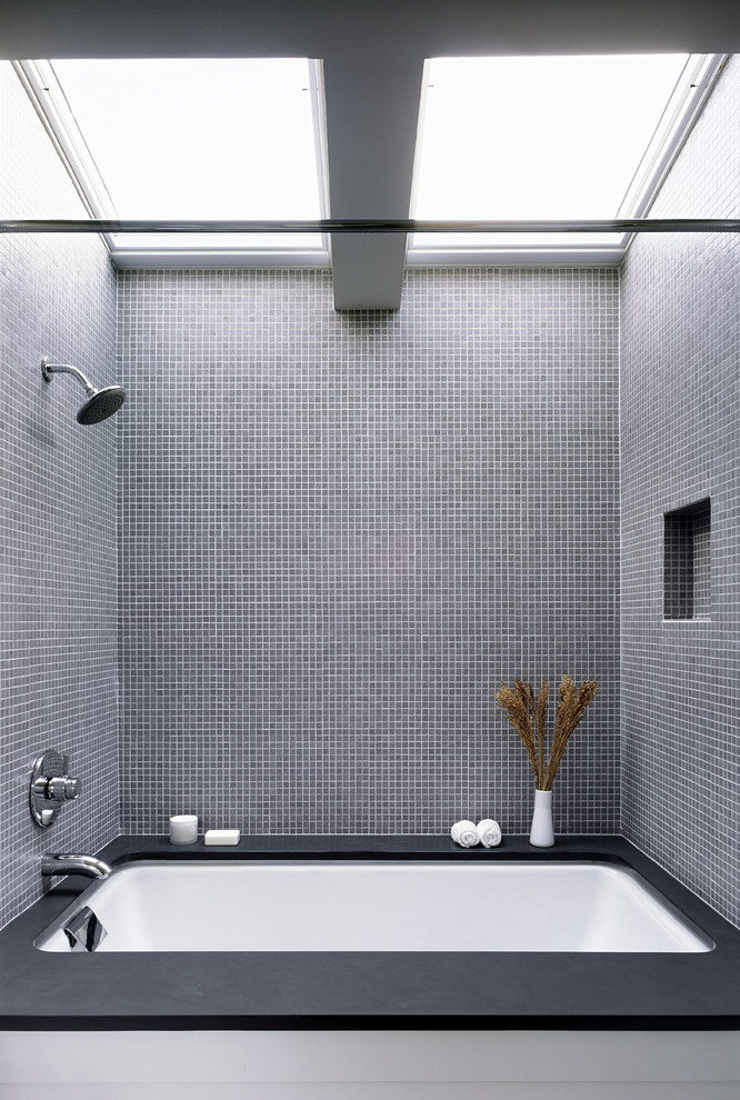 Идея дизайна: ванная комната среднего размера в стиле модернизм с полновстраиваемой ванной, душем над ванной, серой плиткой, плиткой мозаикой, серыми стенами, полом из мозаичной плитки и столешницей из талькохлорита