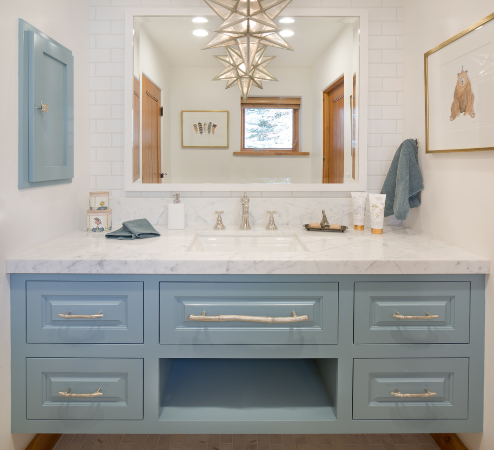 Ejemplo de cuarto de baño tradicional renovado de tamaño medio con armarios con paneles con relieve, puertas de armario azules, paredes blancas, aseo y ducha y lavabo bajoencimera