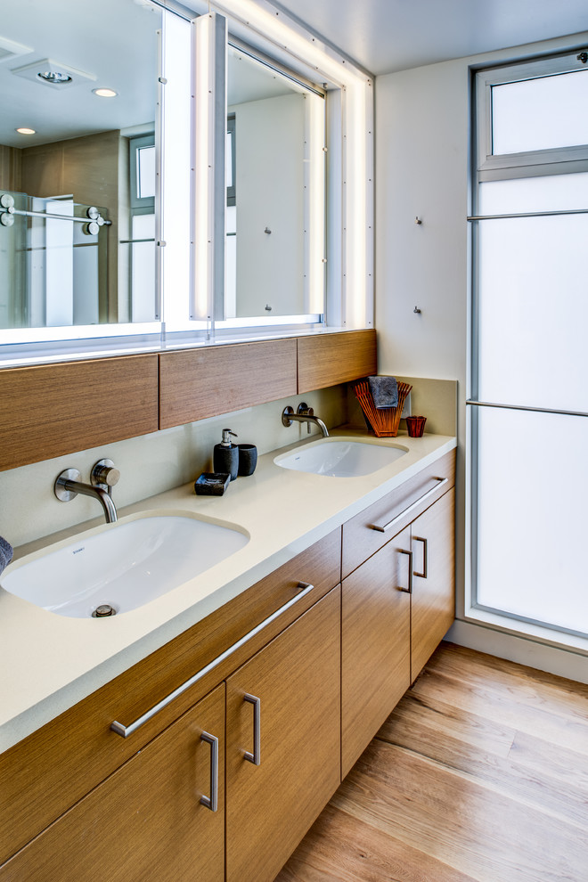 サンフランシスコにあるコンテンポラリースタイルのおしゃれな浴室 (フラットパネル扉のキャビネット、中間色木目調キャビネット、クオーツストーンの洗面台、アンダーカウンター洗面器、白い壁、無垢フローリング) の写真