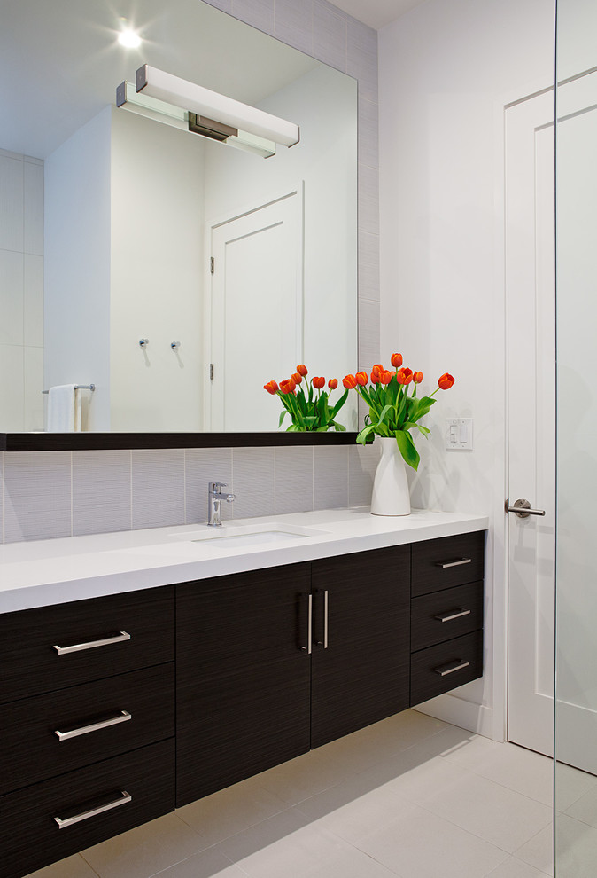 サンフランシスコにあるコンテンポラリースタイルのおしゃれな浴室 (アンダーカウンター洗面器、フラットパネル扉のキャビネット、濃色木目調キャビネット、グレーのタイル、白い壁) の写真