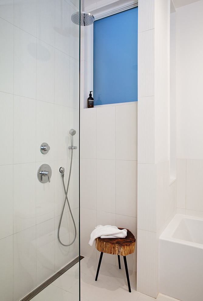 Modern inredning av ett badrum, med ett badkar i en alkov, en öppen dusch, vit kakel och med dusch som är öppen