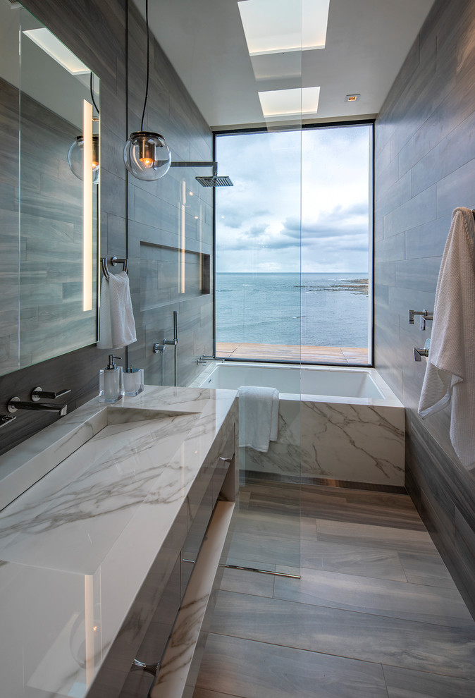 Стильный дизайн: ванная комната в современном стиле с плоскими фасадами, серыми фасадами, полновстраиваемой ванной, душем без бортиков, коричневой плиткой, коричневыми стенами, душевой кабиной, консольной раковиной, коричневым полом, открытым душем и белой столешницей - последний тренд