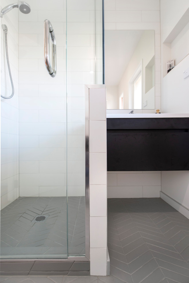 Exempel på ett litet modernt vit vitt en-suite badrum, med släta luckor, svarta skåp, en hörndusch, vit kakel, tunnelbanekakel, vita väggar, klinkergolv i porslin, ett integrerad handfat, bänkskiva i kvarts, grått golv och dusch med gångjärnsdörr