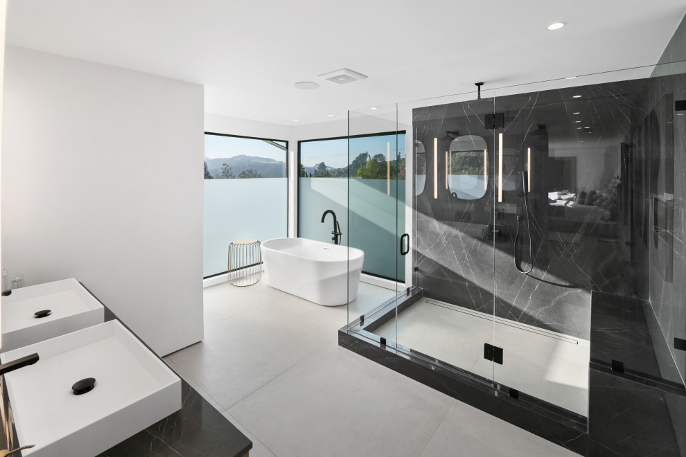 Inspiration pour une salle de bain design avec une baignoire indépendante, un carrelage noir, des dalles de pierre, un mur blanc, une vasque, un sol gris, un plan de toilette noir et meuble double vasque.