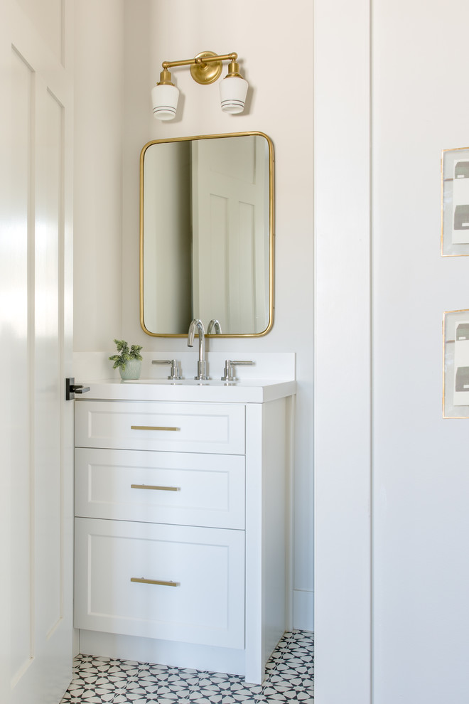 Immagine di una piccola stanza da bagno country con ante con riquadro incassato, ante bianche, pareti bianche, lavabo sottopiano, pavimento bianco e top bianco