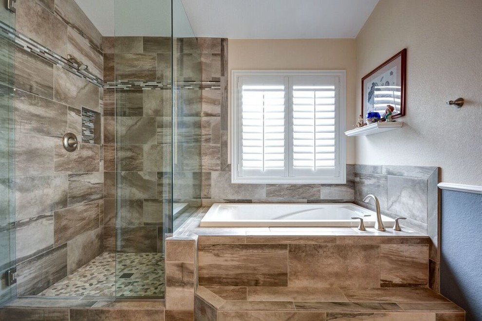 Esempio di una stanza da bagno padronale contemporanea con vasca da incasso, vasca/doccia, piastrelle marroni, piastrelle in ceramica, pareti blu, pavimento con piastrelle di ciottoli e top piastrellato