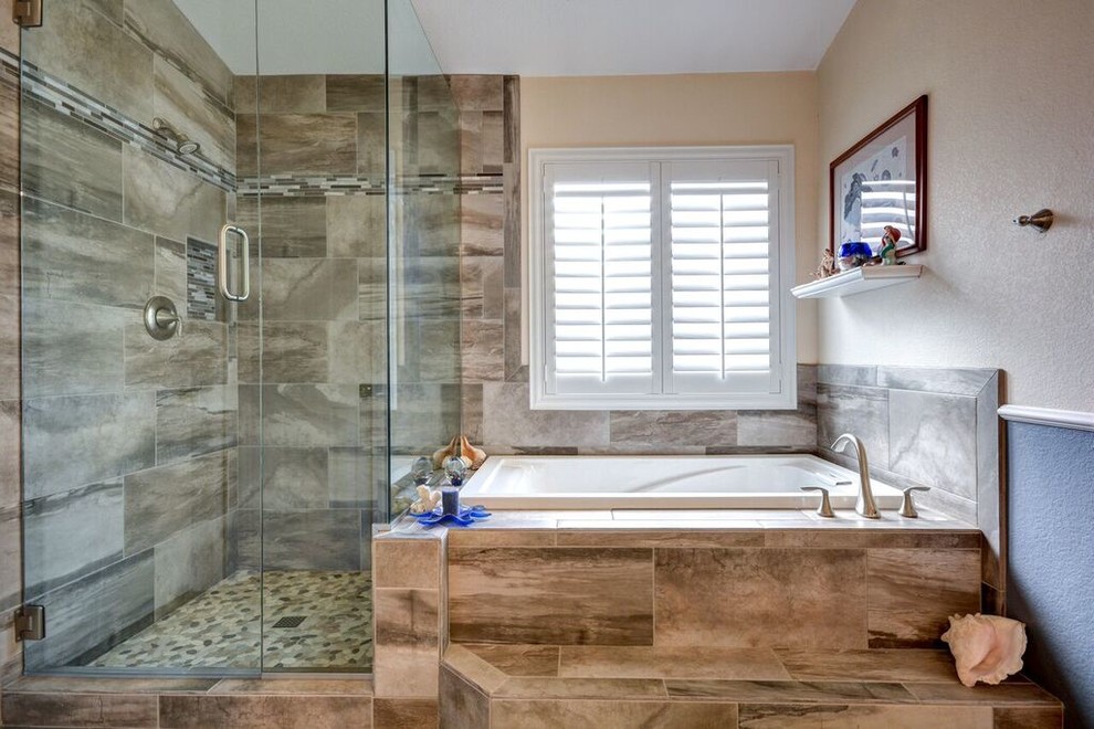 Immagine di una stanza da bagno padronale design con vasca da incasso, vasca/doccia, piastrelle marroni, piastrelle in ceramica, pareti blu, pavimento con piastrelle di ciottoli e top piastrellato