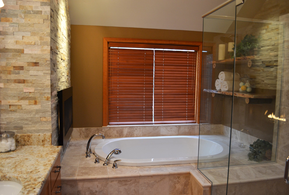 Mid-sized mountain style master brown tile and limestone tile travertine floor and beige floor bathroom photo in Philadelphia with shaker cabinets, medium tone wood cabinets, a two-piece toilet, multicolored walls, an undermount sink, granite countertops and a hinged shower door
