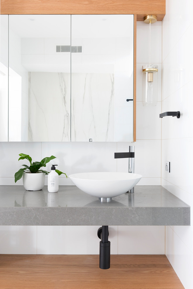 Immagine di una stanza da bagno stile marino con piastrelle bianche, lavabo a bacinella e top grigio