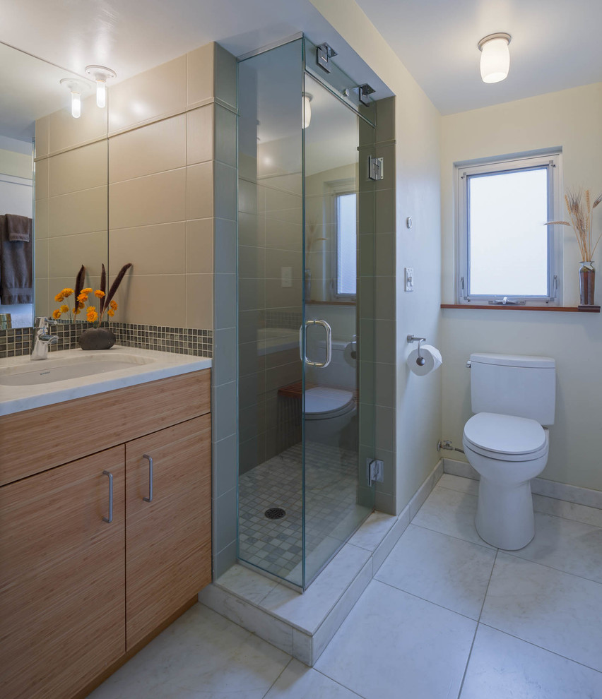 Inspiration for a small contemporary sauna bathroom in Seattle with a submerged sink, flat-panel cabinets, medium wood cabinets, marble worktops, a two-piece toilet, green tiles, ceramic tiles, beige walls and marble flooring.