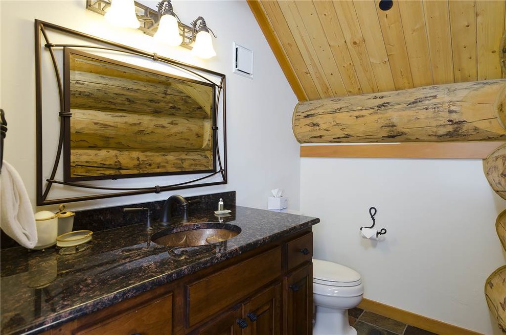 Идея дизайна: ванная комната среднего размера в стиле рустика с фасадами с выступающей филенкой, темными деревянными фасадами, унитазом-моноблоком, белыми стенами, полом из сланца, душевой кабиной, врезной раковиной и столешницей из гранита