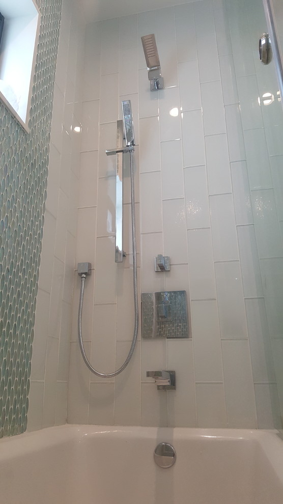 На фото: ванная комната среднего размера в стиле модернизм с плоскими фасадами, белыми фасадами, ванной в нише, душем над ванной, унитазом-моноблоком, серой плиткой, металлической плиткой, серыми стенами, мраморным полом, монолитной раковиной, столешницей из искусственного камня, серым полом и душем с раздвижными дверями с