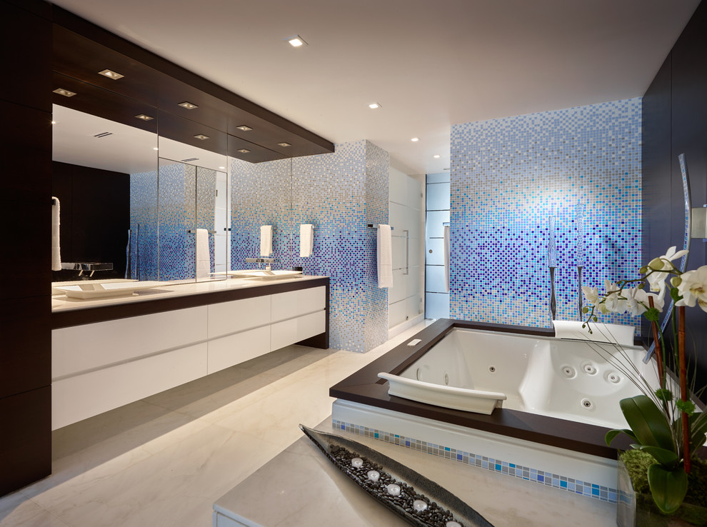 Ejemplo de cuarto de baño contemporáneo con lavabo sobreencimera, armarios con paneles lisos, puertas de armario blancas, bañera encastrada sin remate, ducha empotrada, baldosas y/o azulejos multicolor y baldosas y/o azulejos en mosaico