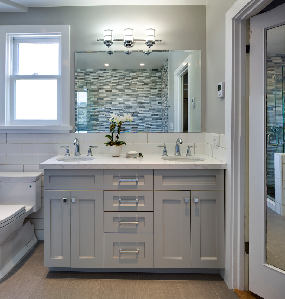 Example of a mid-sized transitional master multicolored tile and glass tile porcelain tile bathroom design in San Francisco with an undermount sink, recessed-panel cabinets, gray cabinets, quartz countertops, a one-piece toilet and gray walls