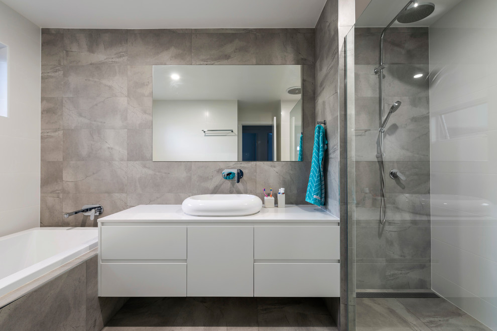 Свежая идея для дизайна: главная ванная комната в современном стиле с плоскими фасадами, белыми фасадами, накладной ванной, душем без бортиков, серой плиткой, серыми стенами, настольной раковиной и серым полом - отличное фото интерьера