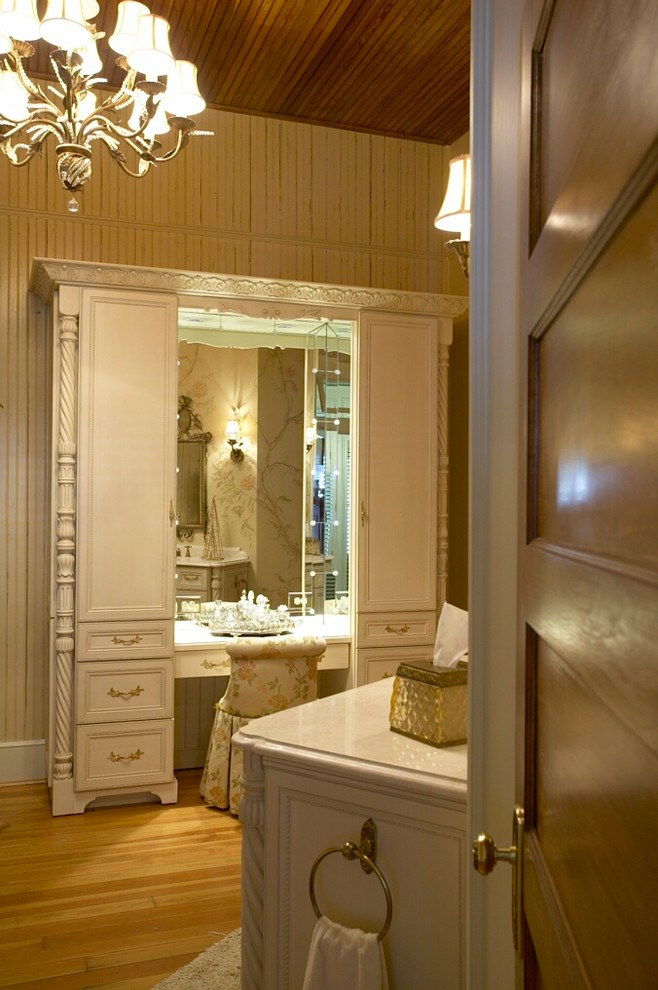 Exemple d'une salle de bain principale victorienne avec un placard en trompe-l'oeil, des portes de placard blanches, un mur blanc et un sol en bois brun.