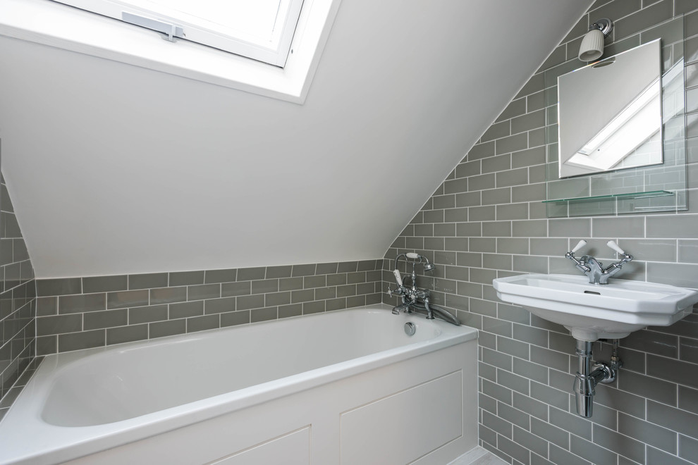 Cette image montre une petite salle de bain traditionnelle avec une baignoire posée, un combiné douche/baignoire, un carrelage gris, des carreaux de céramique, un mur blanc, un sol en carrelage de céramique et un lavabo suspendu.