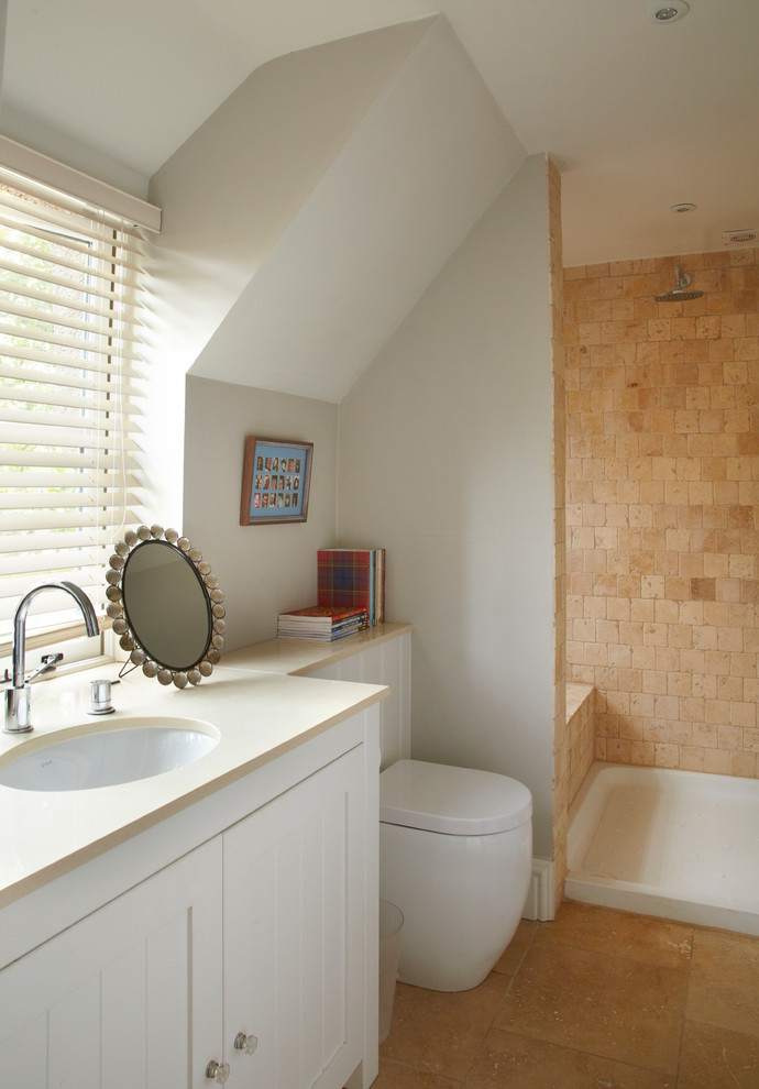 Inspiration pour une salle de bain rustique de taille moyenne avec un lavabo encastré, un placard à porte shaker, une douche ouverte, WC à poser, un carrelage beige, un mur gris et un sol en travertin.