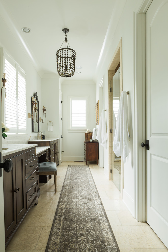 Medium sized traditional ensuite bathroom in Nashville with freestanding cabinets, dark wood cabinets, a built-in shower, a two-piece toilet, beige tiles, travertine tiles, white walls, travertine flooring, a submerged sink, marble worktops, beige floors and a hinged door.