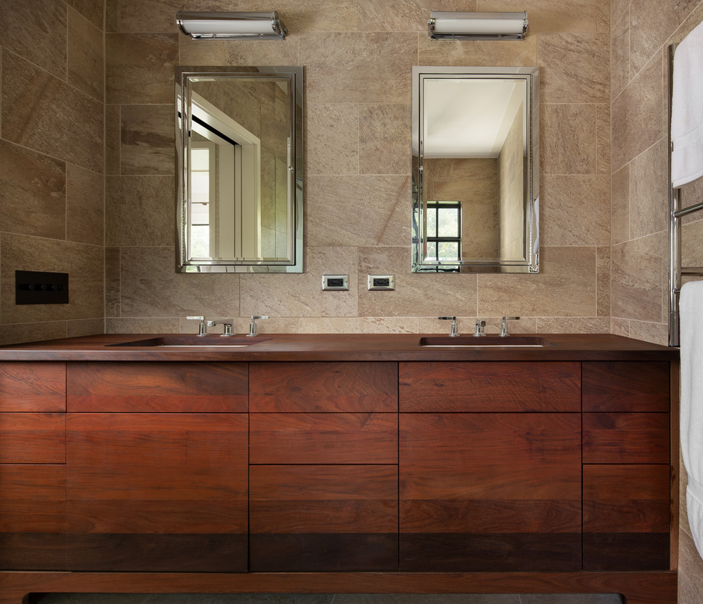 Réalisation d'une grande salle de bain principale champêtre en bois brun avec un placard à porte plane, un lavabo encastré, un plan de toilette en bois, un plan de toilette marron, un carrelage beige, un mur beige et meuble double vasque.