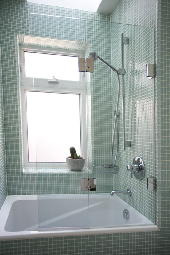 Modelo de cuarto de baño clásico de tamaño medio con baldosas y/o azulejos de vidrio, aseo y ducha, combinación de ducha y bañera, bañera empotrada, baldosas y/o azulejos verdes, paredes verdes y ducha con puerta con bisagras