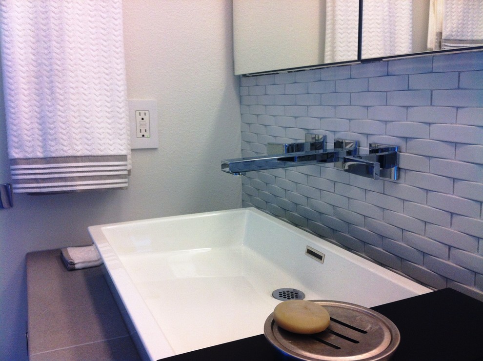 Small contemporary ensuite bathroom in San Diego with a vessel sink, flat-panel cabinets, white cabinets, tiled worktops, a walk-in shower, a two-piece toilet, grey tiles, porcelain tiles, white walls and porcelain flooring.