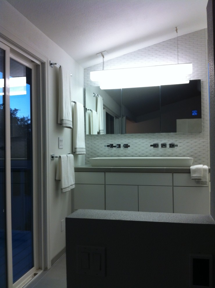 Photo of a small contemporary ensuite bathroom in San Diego with a vessel sink, flat-panel cabinets, white cabinets, tiled worktops, a walk-in shower, a two-piece toilet, grey tiles, porcelain tiles, white walls and porcelain flooring.