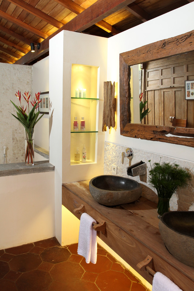 他の地域にあるトロピカルスタイルのおしゃれな浴室 (ベッセル式洗面器、木製洗面台、ブラウンの洗面カウンター) の写真