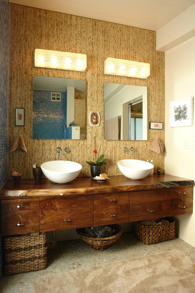 Idéer för att renovera ett stort tropiskt en-suite badrum, med ett fristående handfat, träbänkskiva, blå kakel, glaskakel, bruna väggar, klinkergolv i småsten, släta luckor och skåp i mörkt trä