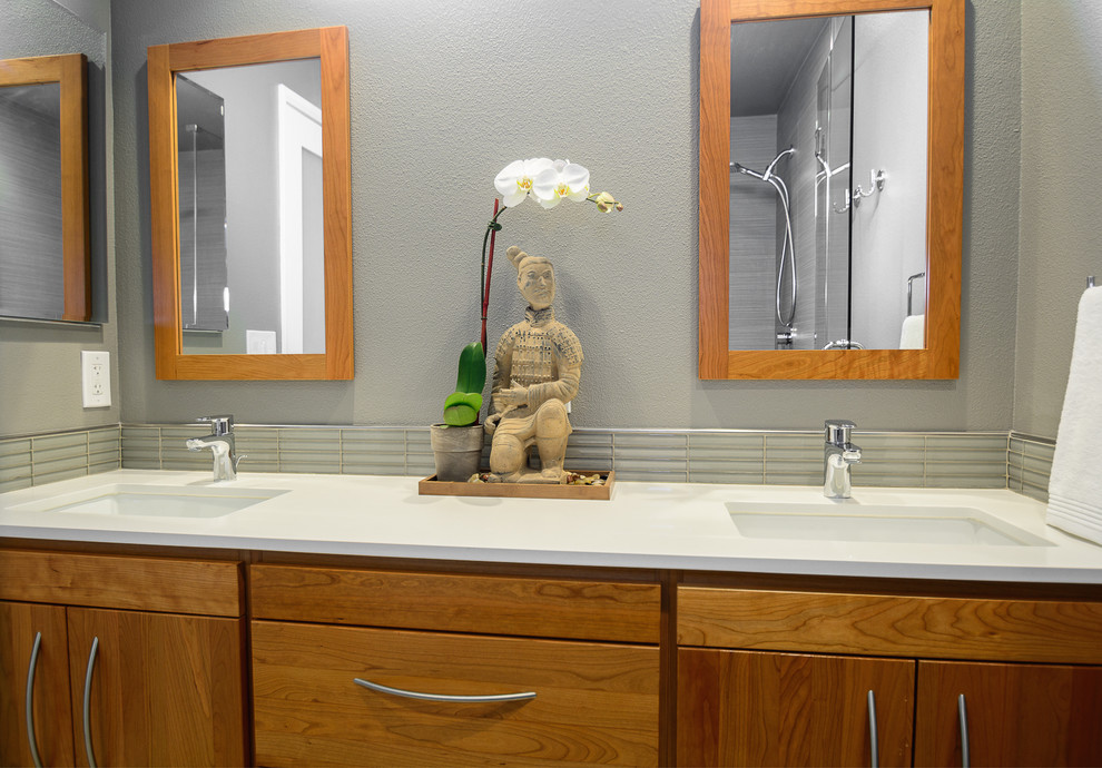 Cette image montre une grande salle de bain principale asiatique en bois brun avec un placard à porte plane, une douche d'angle, un carrelage beige, des carreaux de porcelaine, un mur gris, un sol en carrelage de porcelaine, un lavabo encastré et un plan de toilette en quartz.