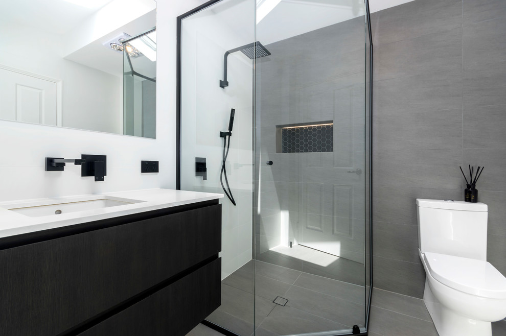 Design ideas for a contemporary bathroom in Perth with black cabinets, a freestanding bath, a double shower, a one-piece toilet, white tiles, porcelain tiles, white walls, porcelain flooring, a submerged sink, engineered stone worktops, grey floors and a hinged door.