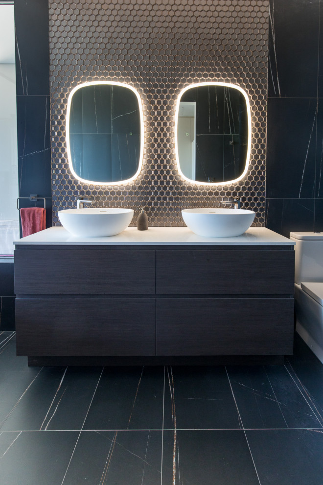 На фото: главная ванная комната в стиле модернизм с отдельно стоящей ванной, унитазом-моноблоком, черными стенами и черным полом с