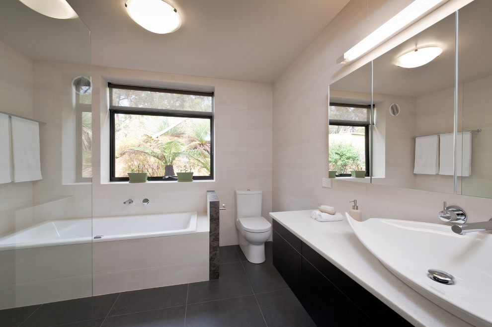 Ispirazione per una stanza da bagno padronale minimal di medie dimensioni con ante nere, vasca da incasso, doccia aperta, WC monopezzo e pareti beige