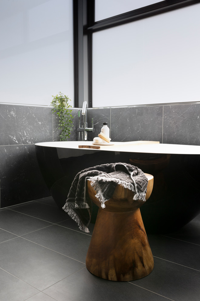 Inspiration for a medium sized modern ensuite bathroom in Canberra - Queanbeyan with freestanding cabinets, white cabinets, a freestanding bath, a walk-in shower, black tiles, porcelain tiles, a vessel sink, wooden worktops, an open shower, a one-piece toilet, black walls, porcelain flooring and black floors.