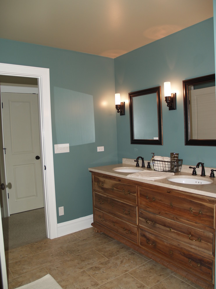 Immagine di una stanza da bagno chic di medie dimensioni con lavabo sottopiano, consolle stile comò, ante in legno scuro, top in superficie solida, piastrelle beige, piastrelle in ceramica, pareti blu e pavimento con piastrelle in ceramica