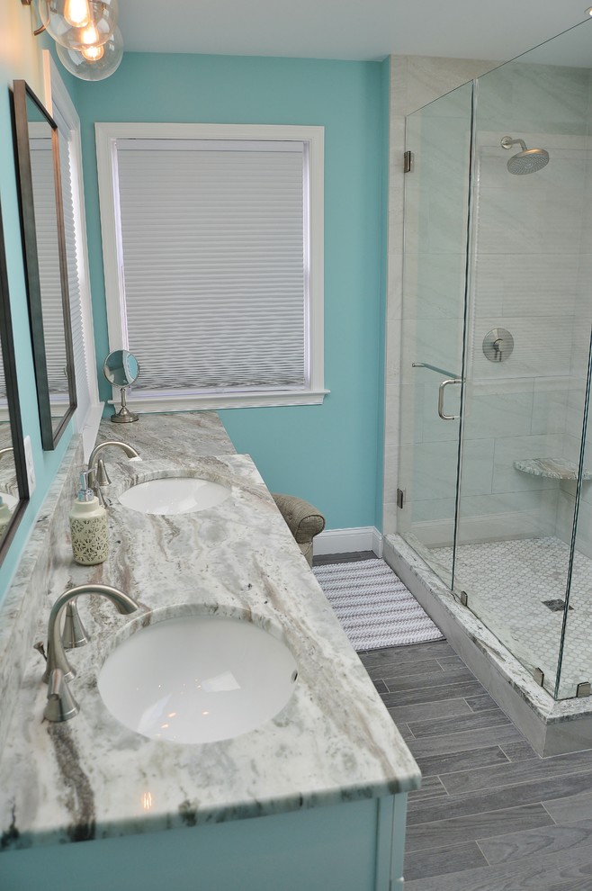 Photo of a large classic ensuite bathroom in Philadelphia with raised-panel cabinets, white cabinets, a freestanding bath, a corner shower, a one-piece toilet, beige tiles, ceramic tiles, blue walls, ceramic flooring, a submerged sink, quartz worktops, brown floors, a hinged door and beige worktops.