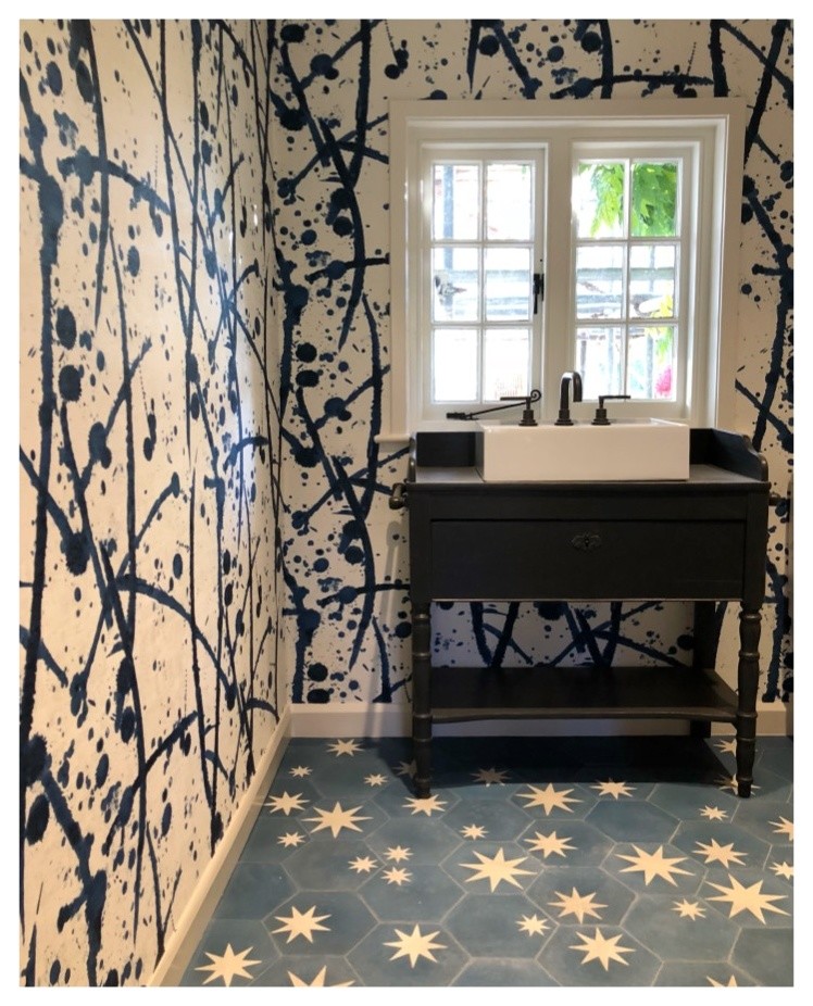 Immagine di una piccola stanza da bagno eclettica con consolle stile comò, ante nere, pareti blu, pavimento in cementine, lavabo a consolle e pavimento blu