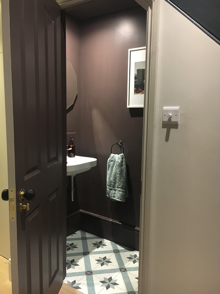 This is an example of a contemporary cloakroom in London with brown walls and terrazzo flooring.