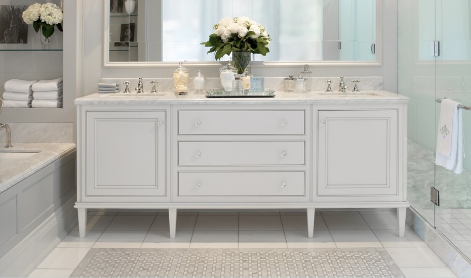 Cette image montre une salle de bain principale traditionnelle avec un lavabo encastré, un placard à porte affleurante, des portes de placard blanches, un plan de toilette en marbre, un mur gris, un sol en carrelage de porcelaine et une baignoire encastrée.