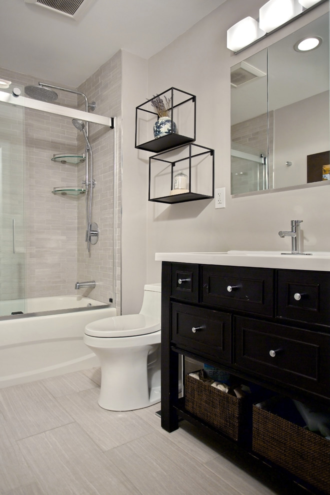 Example of a small transitional master gray tile and porcelain tile porcelain tile and gray floor bathroom design in Boston with furniture-like cabinets, dark wood cabinets, a one-piece toilet, gray walls, an integrated sink, quartz countertops and white countertops