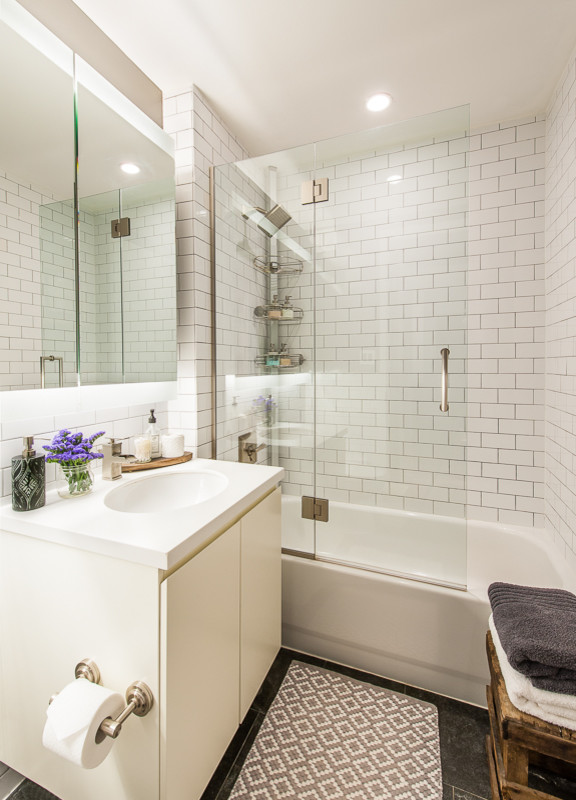 Inredning av ett eklektiskt litet en-suite badrum, med ett undermonterad handfat, vita skåp, bänkskiva i kvarts, ett fristående badkar, en dusch/badkar-kombination, en toalettstol med separat cisternkåpa, vit kakel, tunnelbanekakel, grå väggar och skiffergolv