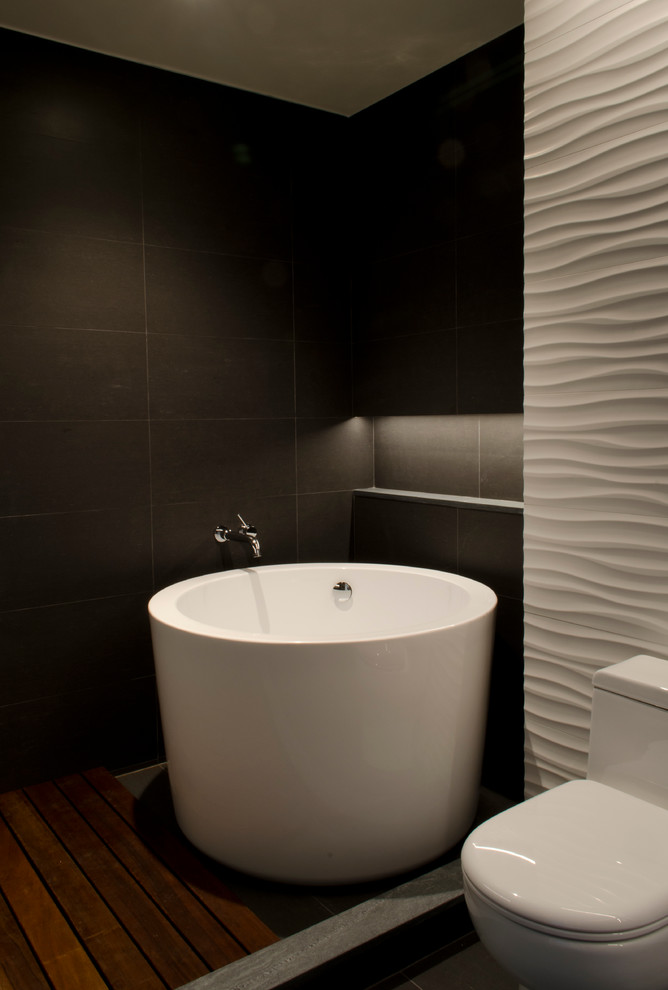 Inredning av ett modernt stort en-suite badrum, med släta luckor, skåp i mörkt trä, ett japanskt badkar, en öppen dusch, en toalettstol med hel cisternkåpa, cementkakel, vita väggar, mörkt trägolv, ett integrerad handfat och bänkskiva i akrylsten